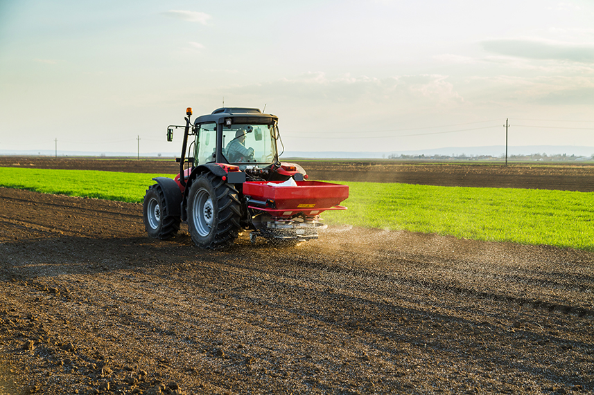 Farmer fertilizing arable land with phosphorus fertilizer.